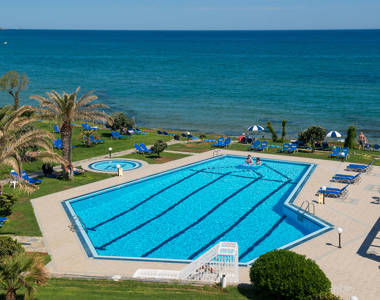 Ariadne Hotel Malia pool with sunbeds on grass and sea view