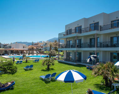 Ariadne Hotel Malia grass with sunbeds and the pool in the background