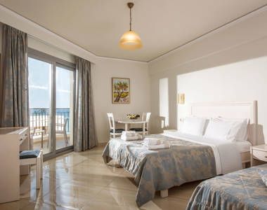 Ariadne Hotel Malia Studio double bed, table with two chairs, balcony view and amenities