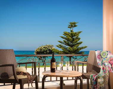 Ariadne Hotel Malia Luxury Studio balcony with two chairs, table with a bottle and two glasses of wine and sea view