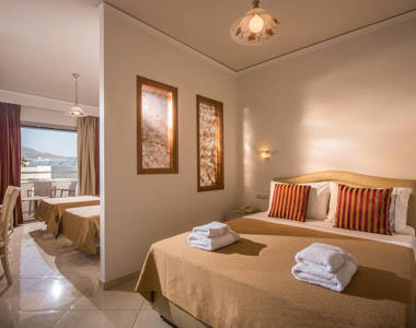 Ariadne Hotel Malia Family Room double bed and two single beds on the other side of a wall